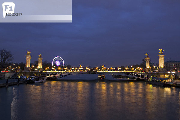 Frankreich  Paris  Brücke Alexandre III bei Nacht. Das Riesenrad im Hintergrund.