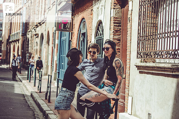 Drei junge Leute unterhalten sich auf der Straße  Stadtbild
