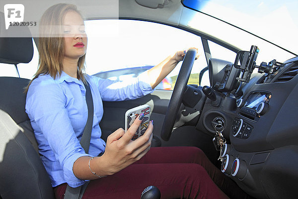 Frankreich  Frau benutzt Smartphone in ihrem Auto.