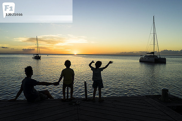 Ein Vater und seine beiden Söhne schauen sich den Sonnenuntergang an  Saint-Pierre  Martinique  Frankreich