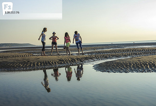 Normandie  Vier Kinder spielen am Strand