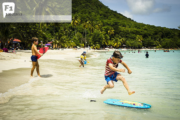 Ein Kind springt auf einem Bodyboard an einem Strand  Anse Figuier  Martinique  Frankreich