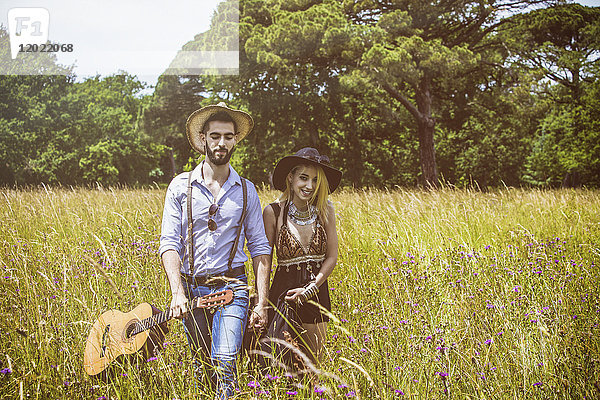 Porträt eines jungen Paares Hipster Fahrt in das Land  hält in der einen Hand eine Gitarre die andere