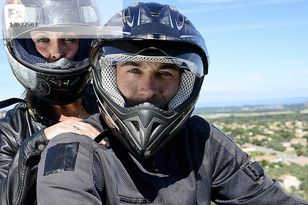 Glückliches junges Bikerpaar beim Motorradfahren im Sommer.
