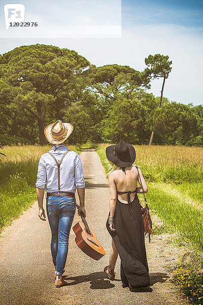 Junges Paar Hipster Fahrt auf dem Land  eine Gitarre in der Hand