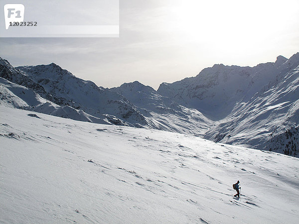 Österreich Nordtirol Stubaier Alpen Fotschtal  ein einsamer Mann wandert mit Schneestiefeln im Neuschnee durch eine Landschaft mit hohen verschneiten Bergen
