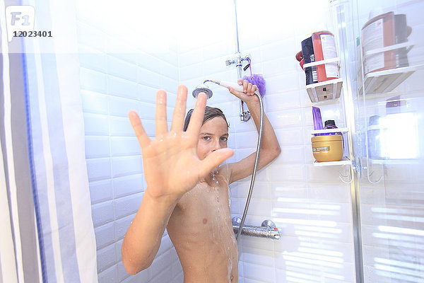 Frankreich  kleiner Junge im Badezimmer unter der Dusche.