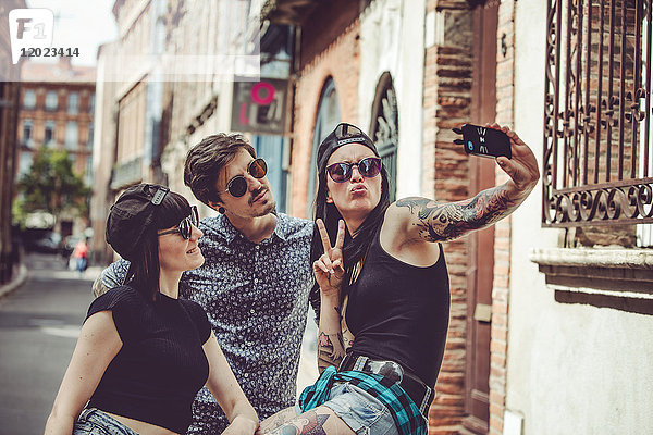 Selfie von drei jungen Menschen in einer Stadtlandschaft