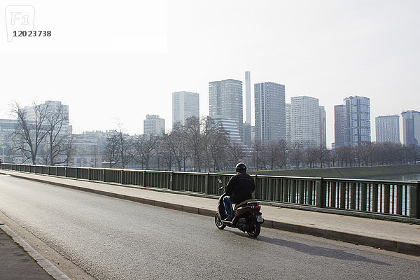 Frankreich  Paris  Bir-Hakeim am Sonntagmorgen  ein Mann fährt im Winter auf einem Motorroller.