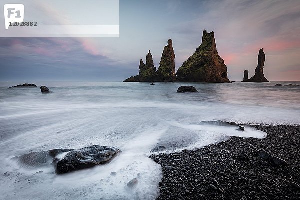 Felsformationen im Meer bei Sonnenuntergang  Langzeitbelichtung  schwarzer Strand  Reynisdrangar  Vik  Island  Europa