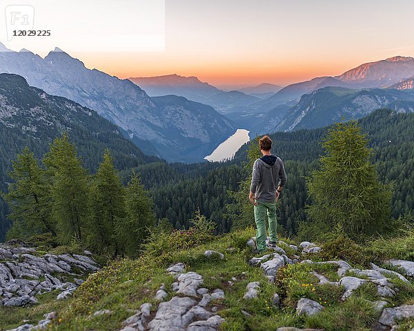 Mann schaut in die Ferne  Bergpanorama  Blick über den Königssee vom Feldkogel  links Watzmann Südspitze und Watzmann-Kinder  rechts Funtenseetauern  Sonnenuntergang  Nationalpark Berchtesgaden  Berchtesgadener Land  Oberbayern  Bayern  Deutschland  Europa