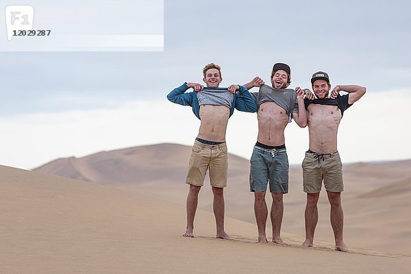 Drei junge Männer zeigen ihren muskulösen Oberkörper  Namib-Wüste  Namibia  Afrika