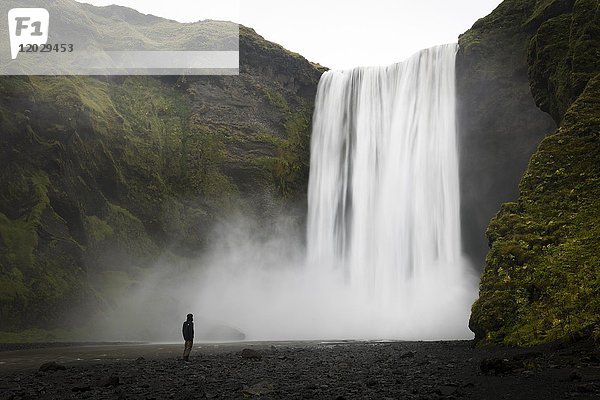 Person vor dem Wasserfall Skogafoss  Langzeitbelichtung  Skogar  Island  Europa
