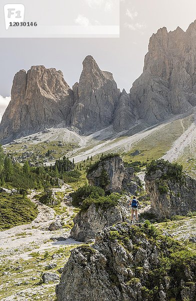 Wanderer auf Felsen stehend  Geröllfeld unterhalb der Geislerspitzen  hinter der Geislergruppe  Villnösstal Sass Rigais  Dolomiten  Südtirol  Italien  Europa