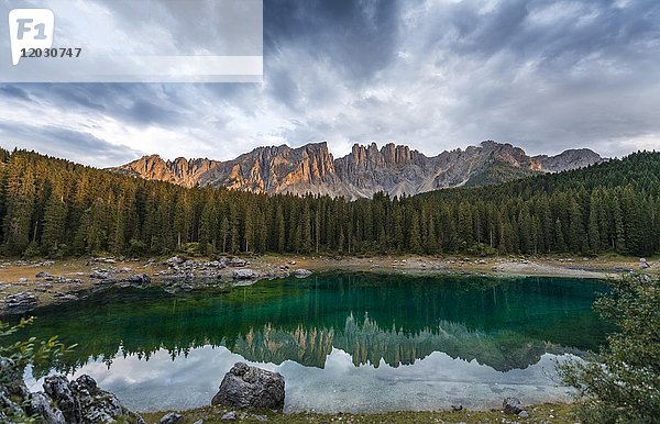 Sonnenuntergang  dramatische Wolken  Latemargruppe spiegelt sich im Karersee  Diamantidturm  Berggipfel  Östliche Latemarspitze  Col Coron  Karersee  Welschnofen  Bozen  Südtirol  Italien  Europa