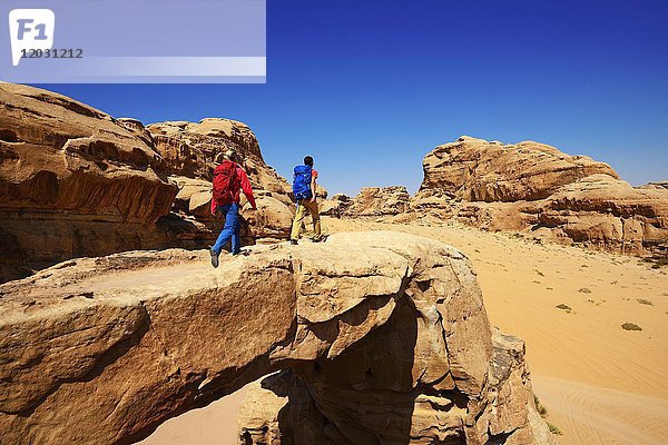 Pärchen beim Wandern am Felsenbogen Um Alfrooth  Wadi Rum  Jordanien  Asien