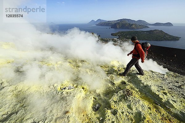 Wanderer auf dem Gran Cratere wandert durch Schwefelfumarolen  Blick auf Lipari  Salinas  Stromboli  Insel Vulcano  Liparische Inseln  Italien.