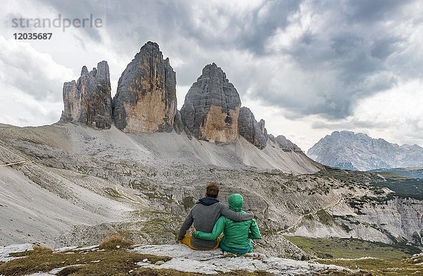 Zwei Wanderer machen eine Pause  Nordwände der Drei Zinnen  Sextner Dolomiten  Südtirol  Trentino-Südtirol  Südtirol  Italien  Europa