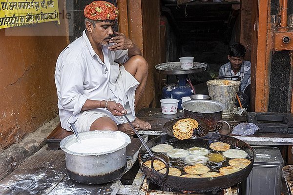 Ein Mann bereitet schmackhafte frittierte Snacks in einer Straßenküche vor  Pushkar  Rajasthan  Indien  Asien