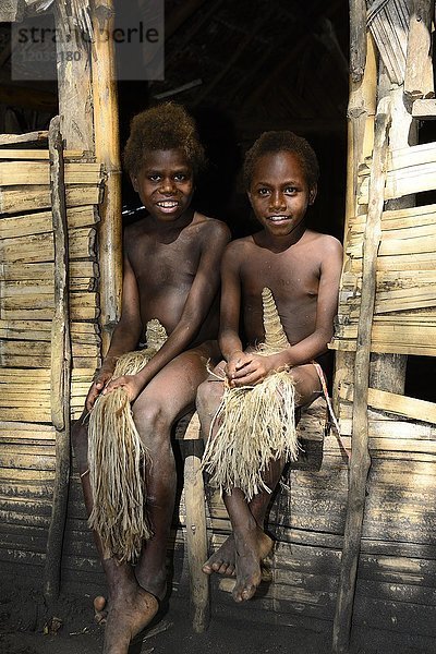Zwei einheimische Kinder sitzen vor Hütte  Yakeel Custom Village  Tanna Island  Vanuatu  Südsee  Ozeanien