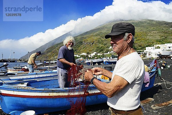 Fischer reparieren Netze am Scari-Strand  im Hintergrund der Vulkan  Insel Stromboli  Liparische Inseln  Italien  Europa