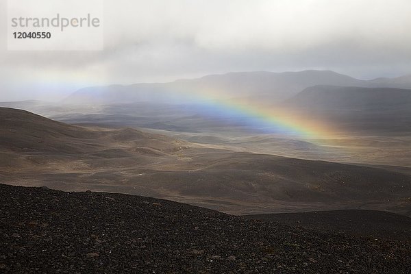 Wuestenhafte  bergige Landschaft mit Regenbogen  Moedrudalsfjallgardur  Hochland  Island  Europa