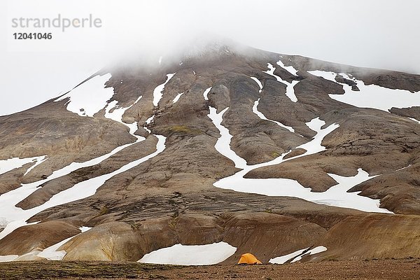 Ein Zelt an einem teilweise mit Schnee bedecktem Rhyolith-Berg  Hochtemperaturgebiet Hveradalir  Kerlingarfjöll  Island  Europa