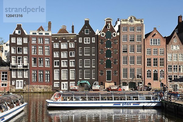 Historische Gebäude und Boot für Grachtenfahrt am Damrak  Amsterdam  Nordholland  Holland  Niederlande  Europa