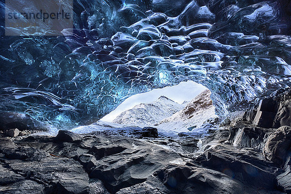Blick aus der Eishöhle unter dem Vatnajokull-Gletscher auf die schneebedeckten Berge in der Nähe der Lagune Jokulsarlon  Südisland  Polarregionen