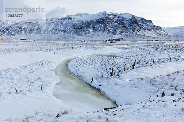 Atemberaubende schneebedeckte Winterlandschaft in der Nachmittagssonne  auf dem Weg zur Snaefellsnes-Halbinsel  Island  Polarregionen