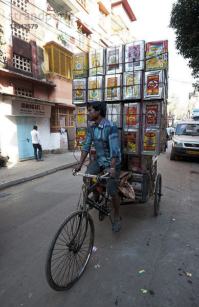 Aufgetürmte leere Öldosen  die mit einer Fahrradrikscha zur Wiederverwertung und zum Bau von Slumwänden transportiert werden  Kolkata (Kalkutta)  Westbengalen  Indien  Asien