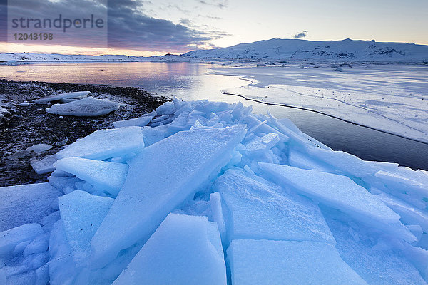 Sonnenuntergang über der zugefrorenen Jokulsarlon Gletscherlagune im Winter  Südisland  Polarregionen