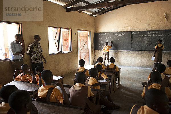 Ein Klassenzimmer mit Schulkindern  die etwas über das Potenzial des Kakaoanbaus lernen  Ghana  Westafrika  Afrika