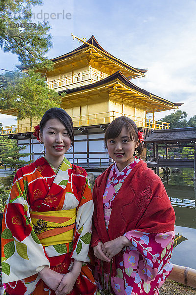 Frauen in traditionellen japanischen Kimonos vor dem Tempel des Goldenen Pavillons (Kinkaku-ji) in Kyoto  Japan  Asien