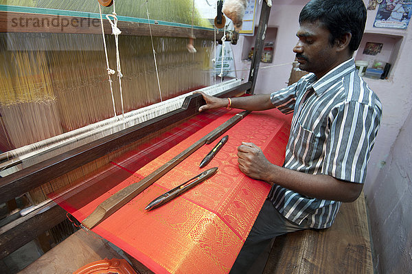 Seidenweber an seinem Webstuhl in seinem Haus  webt den begehrten rot-goldenen Kanchipuram-Seidensari  Kanchipuram  Tamil Nadu  Indien  Asien