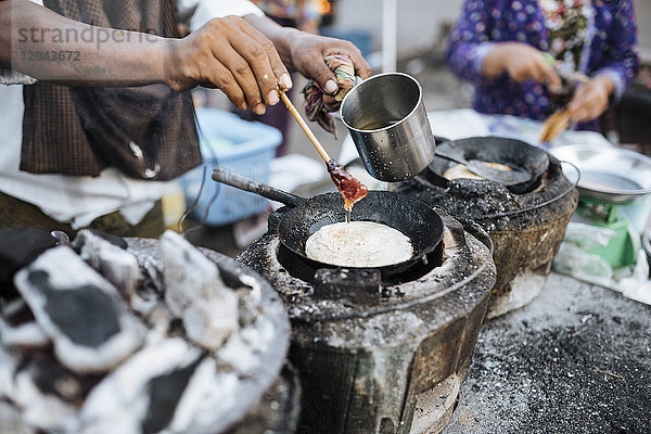 Mann macht Pfannkuchen am Straßenstand  Yangon (Rangun)  Myanmar (Burma)  Asien