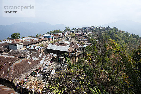 Die Häuser des Naga-Dorfes klammern sich an den Berghang  der zur Baptistenkirche auf dem Gipfel führt  Dorf Chanlangshu  Nagaland  Indien  Asien