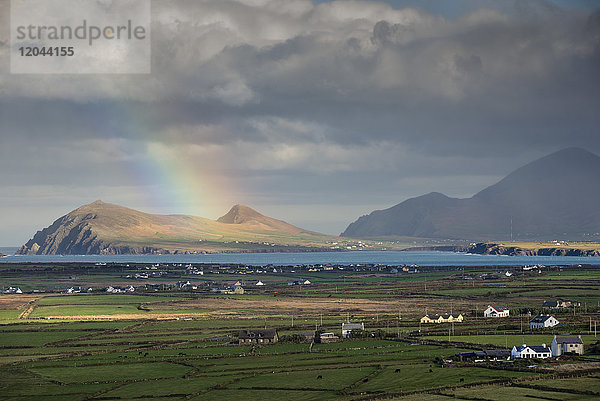 Regenbogen über Hügeln und Siedlungen  Blick in Richtung Clogher und Rosroe  Dingle-Halbinsel  County Kerry  Munster  Republik Irland  Europa