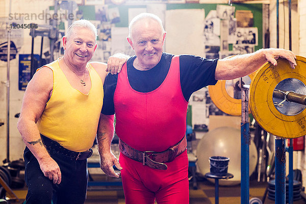 Porträt von zwei älteren männlichen Kraftdreikämpfern im Fitnessstudio