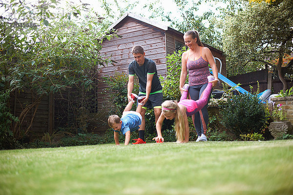 Familie im Garten  mit Schubkarrenrennen