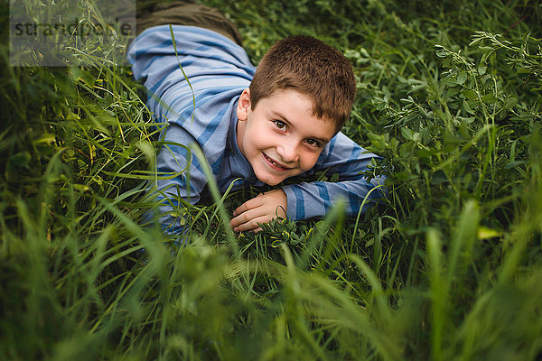 Junge schaut zur Kamera auf grünes Grasfeld