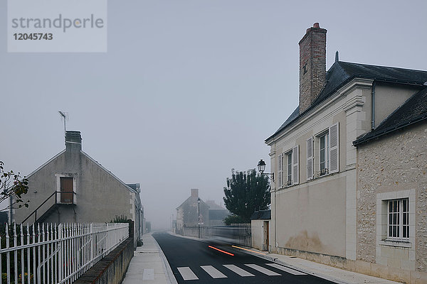Rücklichtspur auf der Straße durch das Dorf Meigne-le-Vicomte an einem nebligen Morgen  Loire-Tal  Frankreich