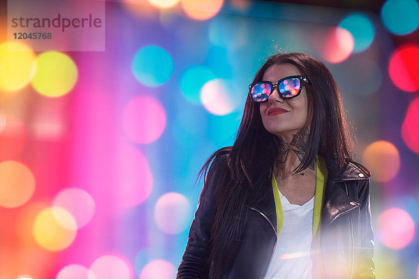 Porträt einer jungen Frau  nachts im Freien  Licht in Brille reflektiert