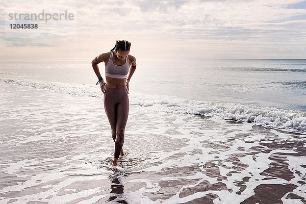 Junge Frau geht im Meer spazieren