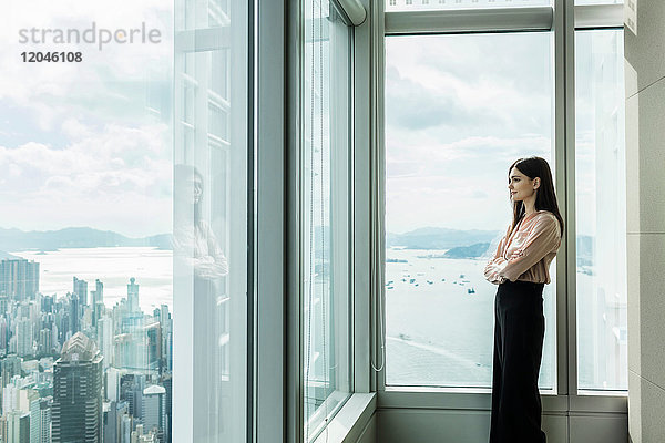 Geschäftsfrau schaut aus dem Fenster auf das Stadtbild
