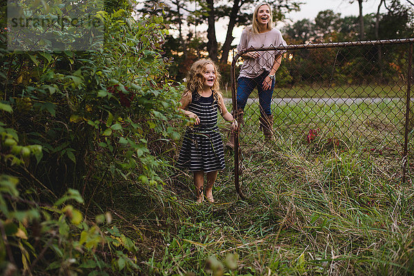 Mutter und Tochter betreten das Tor zum Bauernhof
