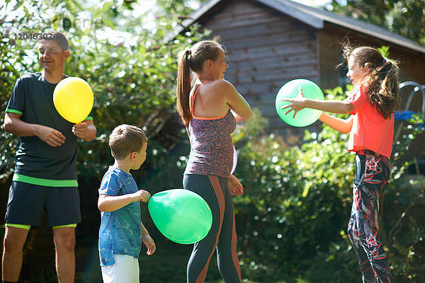 Familie spielt mit Luftballons im Garten