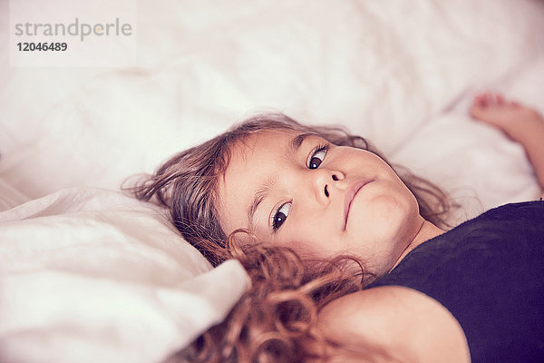 Junges Mädchen auf dem Bett liegend  nachdenkliche Ausdrücke