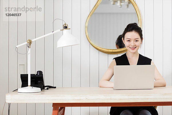 Frau am Schreibtisch mit Laptop