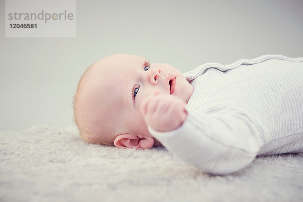 Neugeborenes Baby Junge  auf dem Teppich liegend  Nahaufnahme